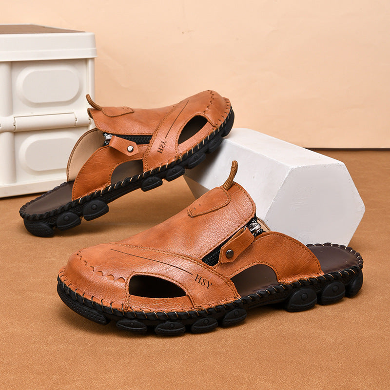 Brown sandals with black soles on a beige surface