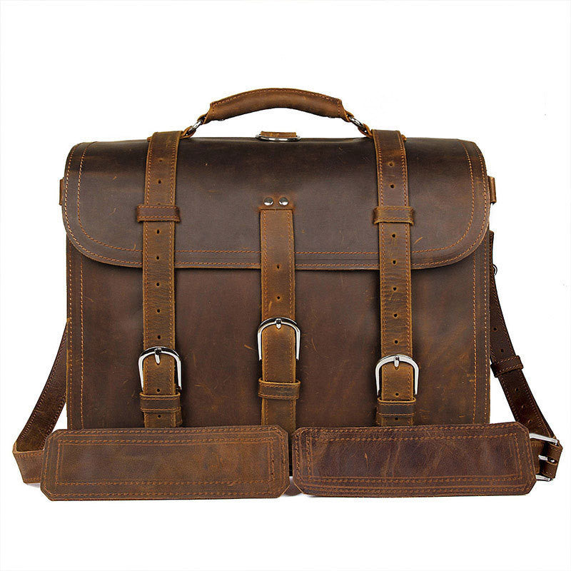 Brown leather satchel bag with straps on a white background