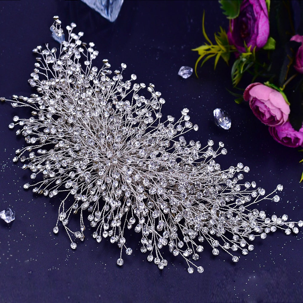 Silver hairpiece with crystals on a dark background with flowers