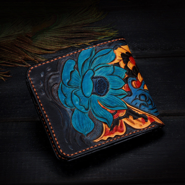 Handcrafted leather wallet with floral design on a dark surface