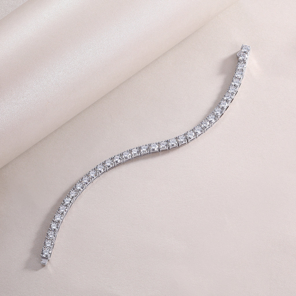 Silver bracelet with clear stones on a light pink background