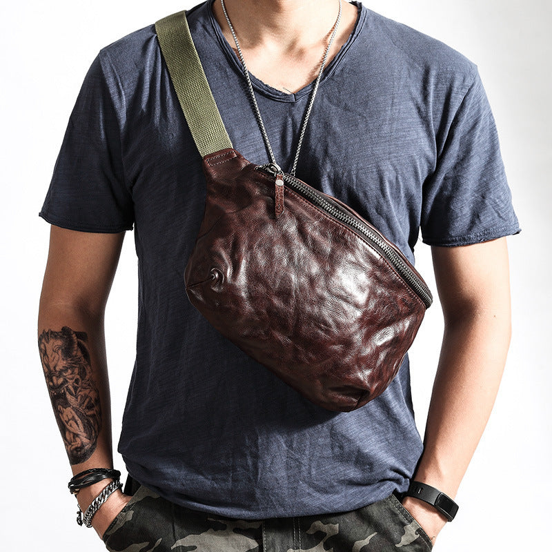 Person wearing a brown leather bag over one shoulder against a white background