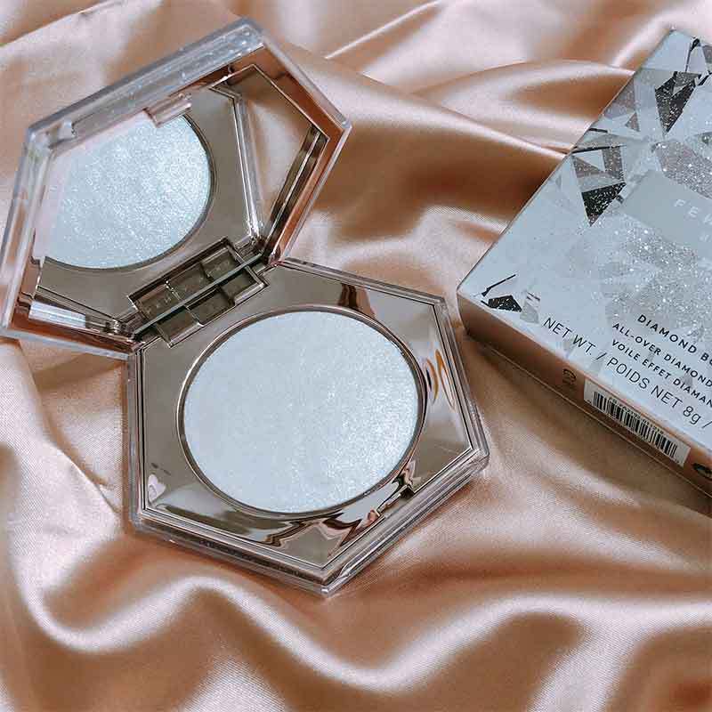 Makeup compact with a diamond-like finish on a pink satin background
