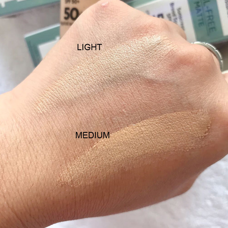 Hand swatches of light and medium makeup shades with product packaging in the background.