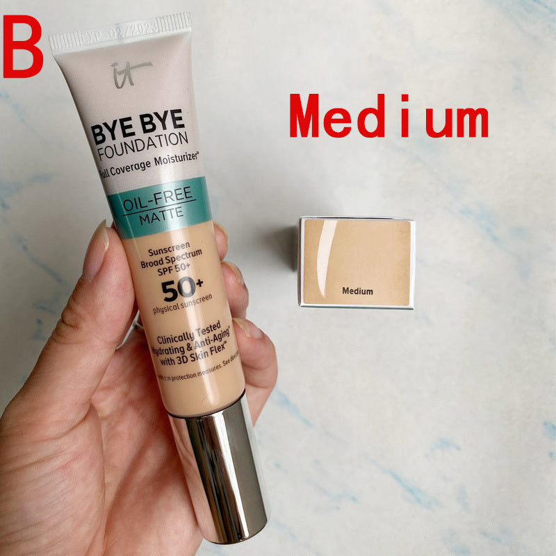 Foundation tube labeled 'Bye Bye Foundation' held by a hand with a swatch labeled 'Medium' on a light background.