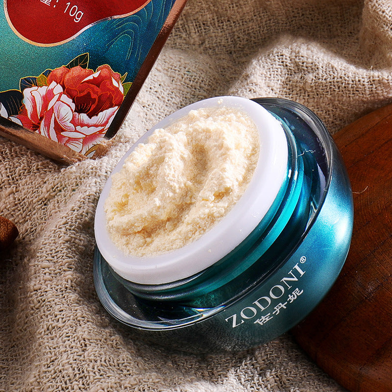 Jar of cream with Zodoni branding on a textured fabric background