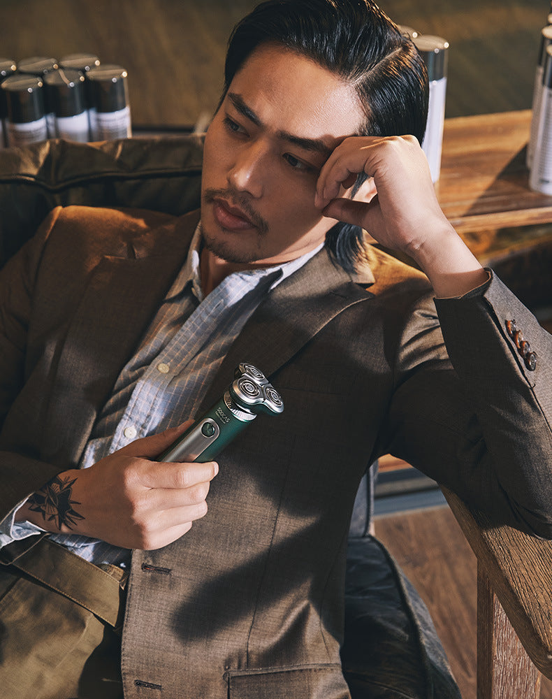 Man in a suit holding a razor in a barbershop setting
