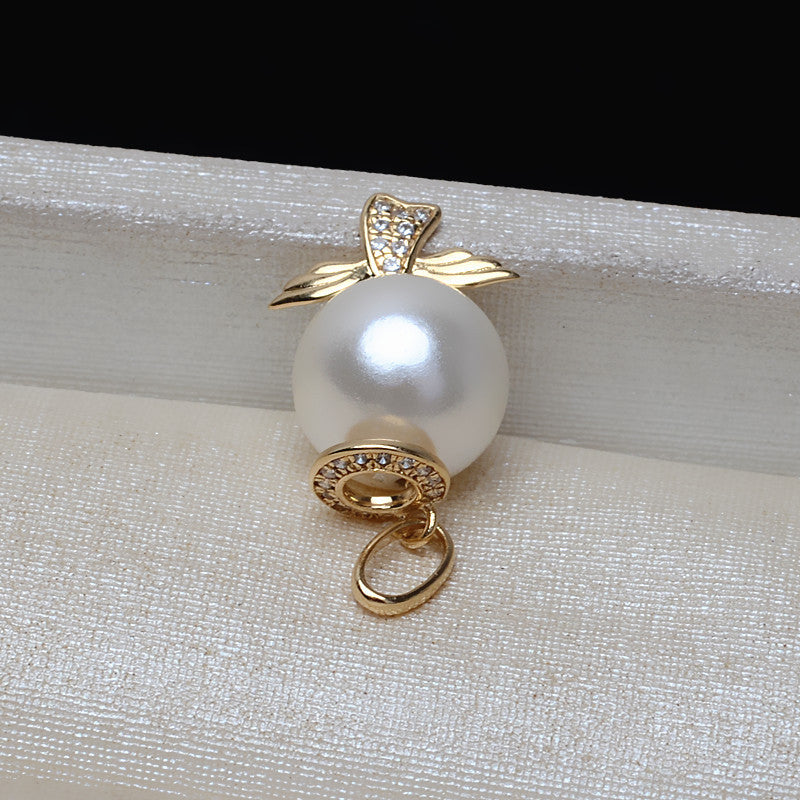 Pearl pendant with gold setting on a textured white surface
