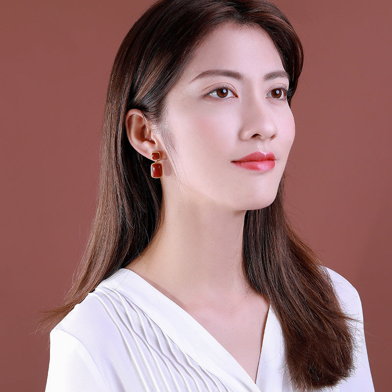 Woman wearing earrings with a plain background