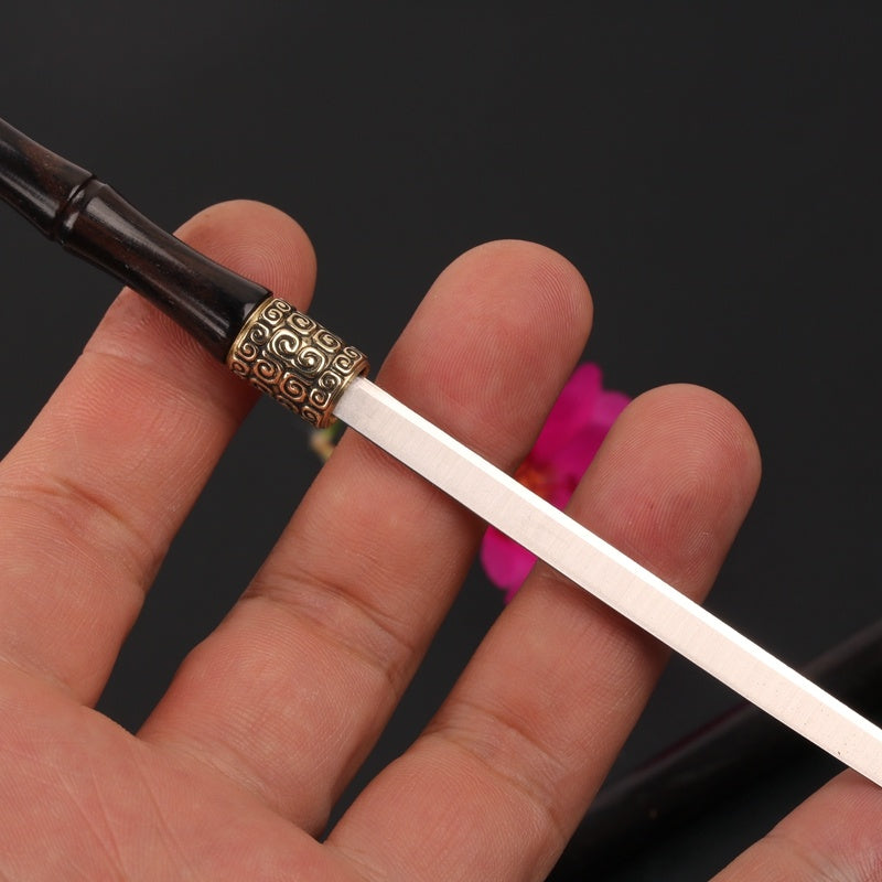 Hand holding a sword with a decorative hilt against a dark background