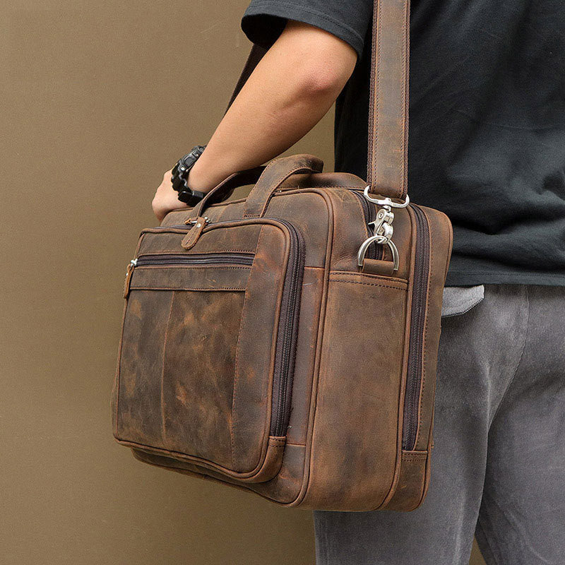 Brown leather briefcase held by a person against a beige background
