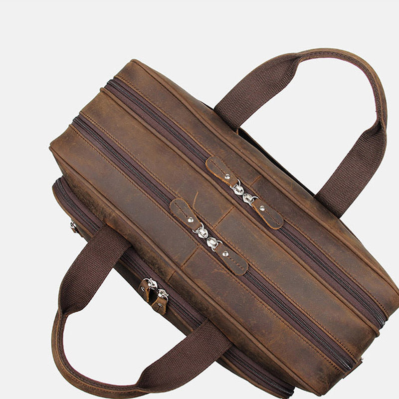 Brown leather briefcase with multiple zippers on a white background