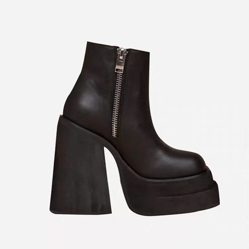 Black platform ankle boot with a zipper on a light gray background