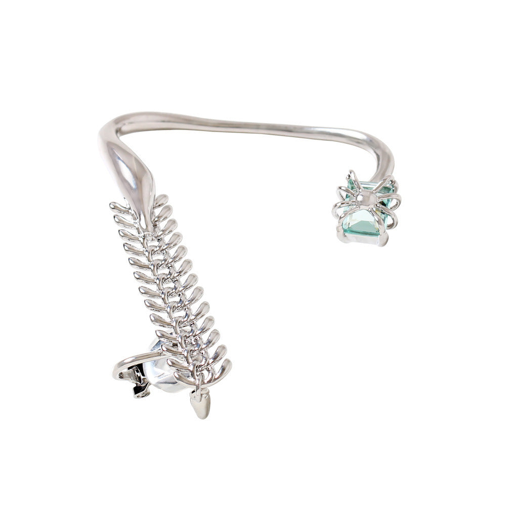 Silver hair clip with green gemstones on a white background