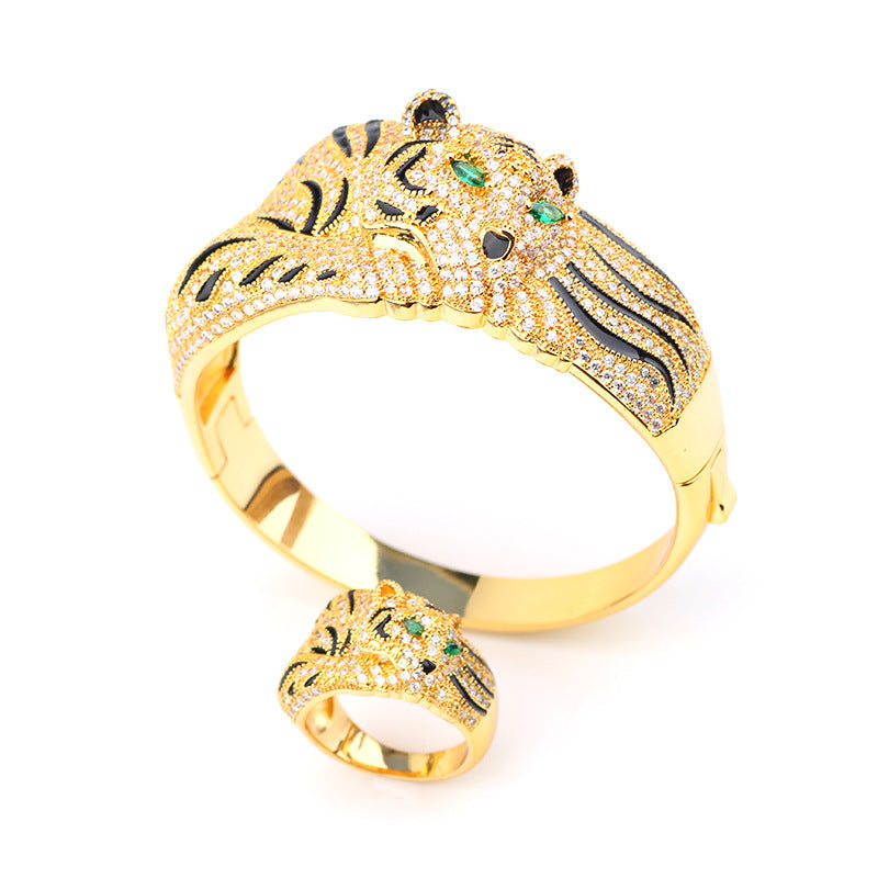 Gold bracelet with tiger design on a white background