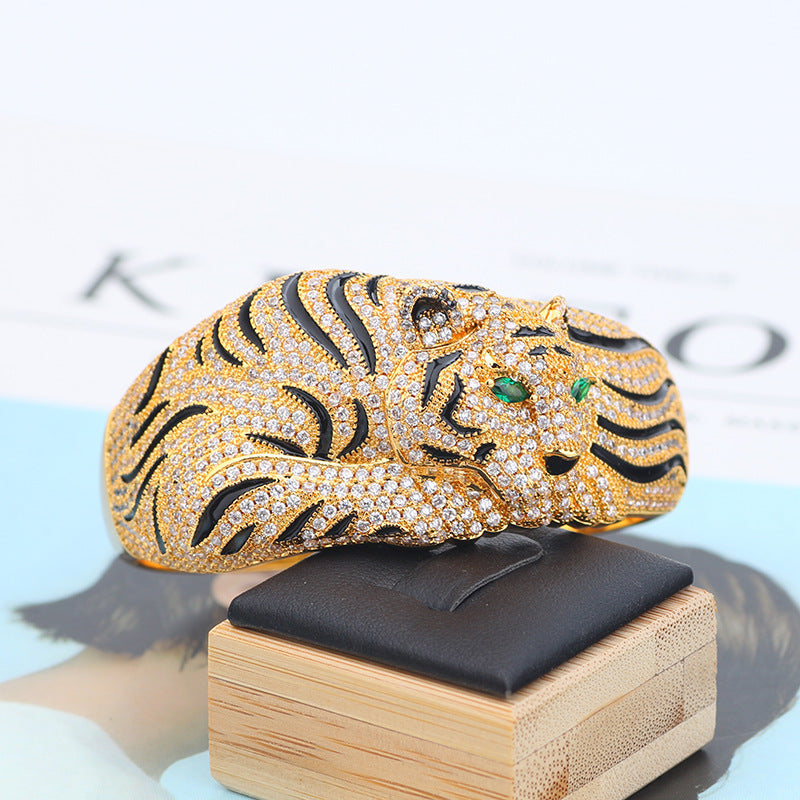 Gold tiger-shaped clutch with gemstones on a wooden stand