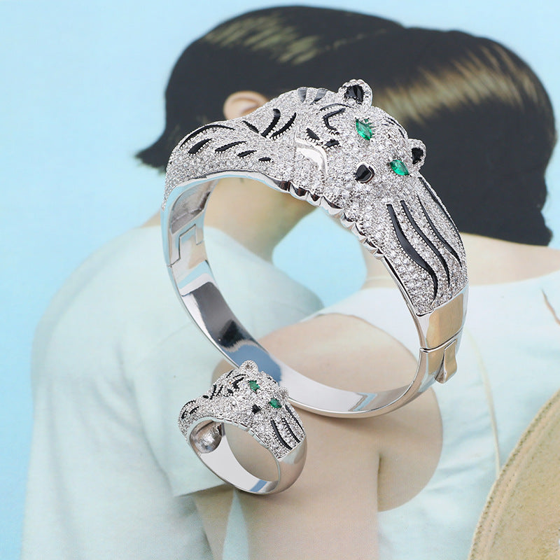 Silver bracelet with tiger design on a mannequin against a light blue background