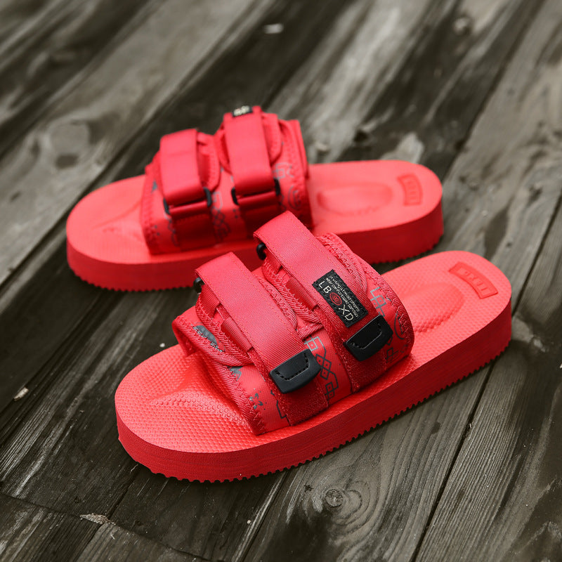 Red sandals with black buckles on a wooden surface