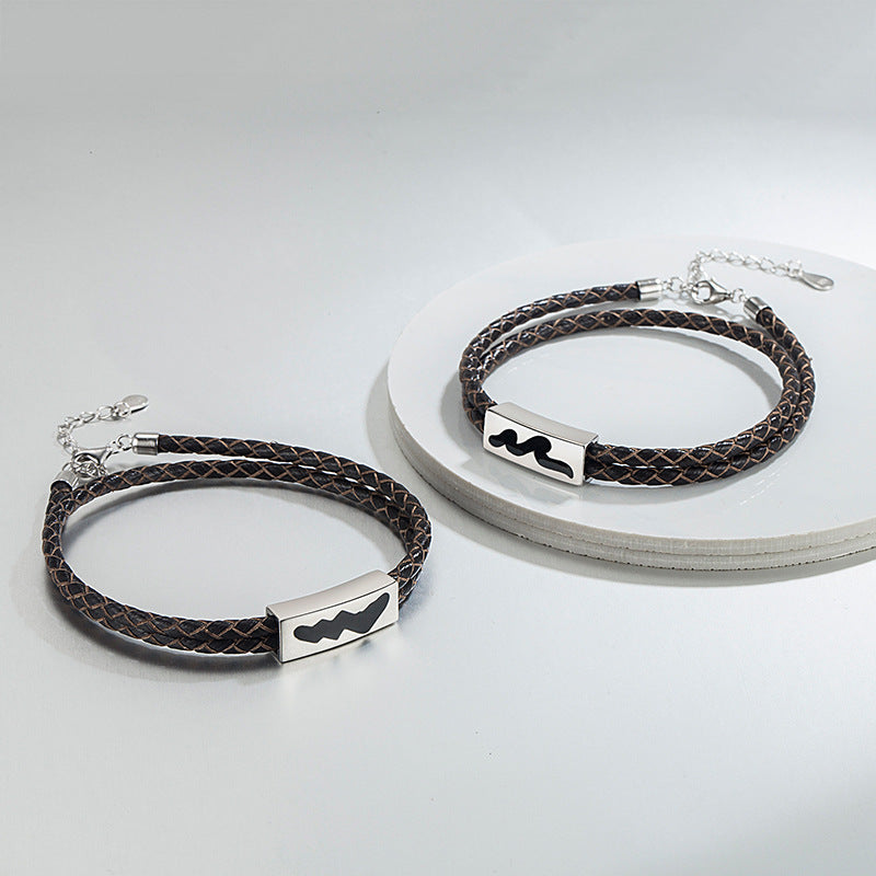 Two brown braided leather bracelets with silver rectangular markers on a light gray background
