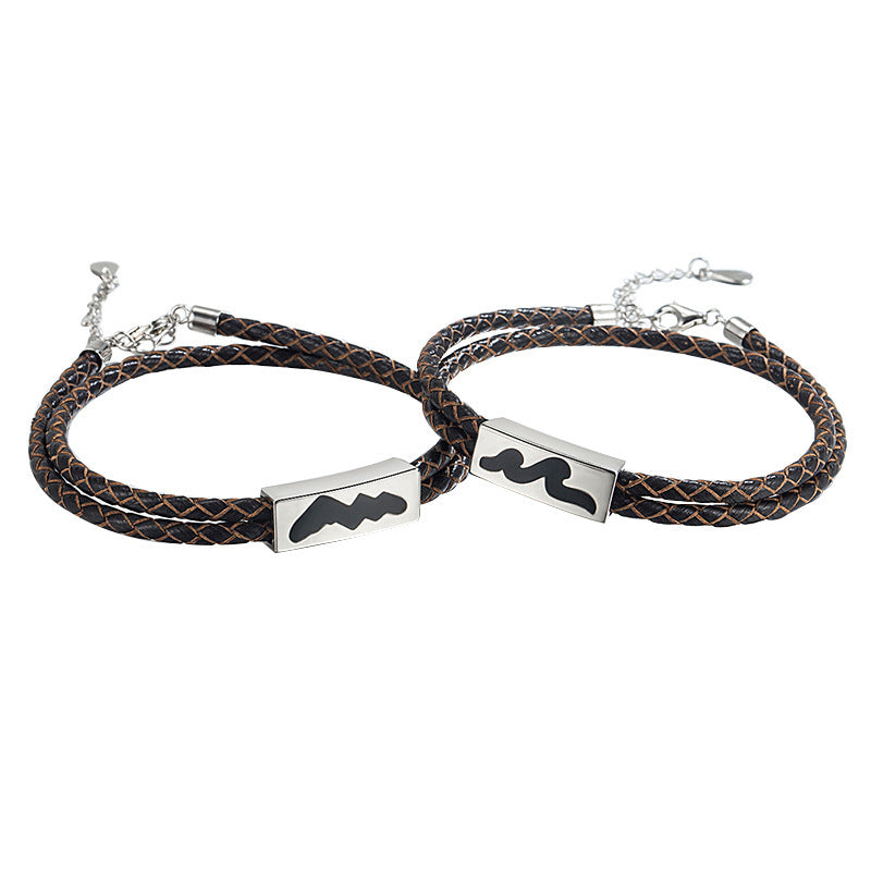 Two braided leather bracelets with metal ends on a white background