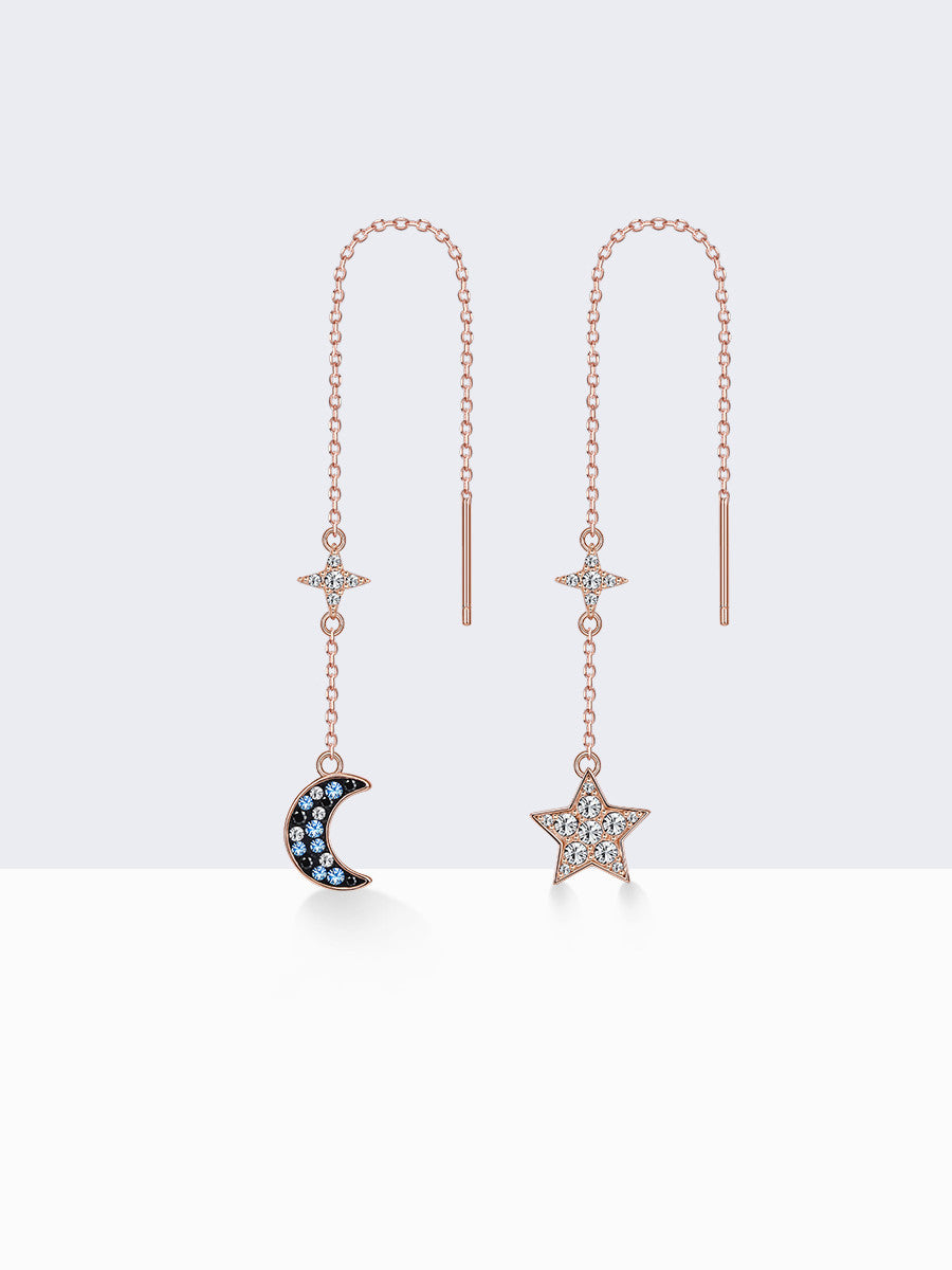Pair of star and moon earrings with gemstones on a white background