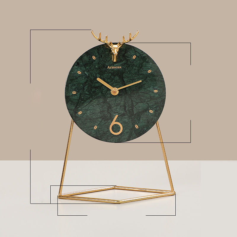 Decorative clock with green marble-like face and gold deer antlers on a beige background