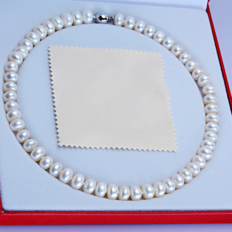 Pearl necklace in a box with a cloth on a white background
