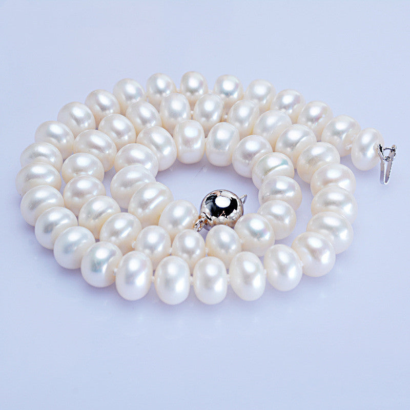 Pearl necklace with a silver clasp on a light purple background
