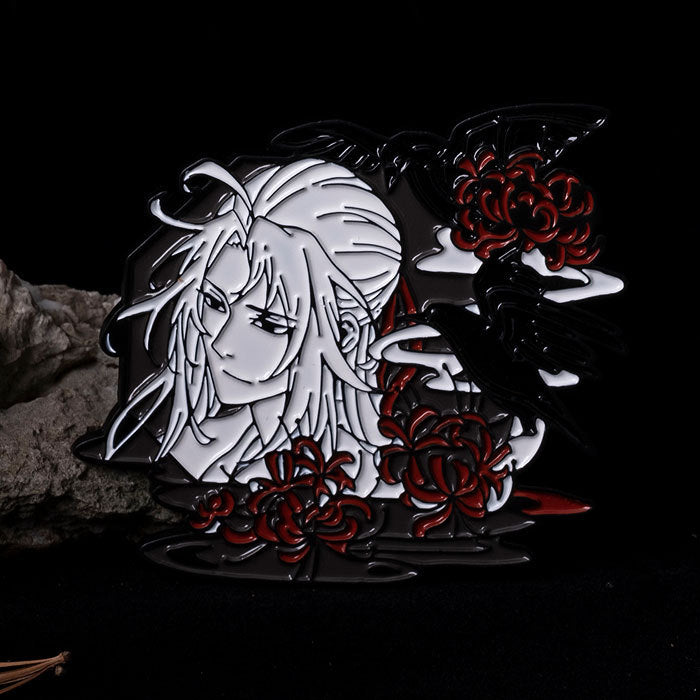 Metallic figurine of a woman with long hair and red flowers on a dark background