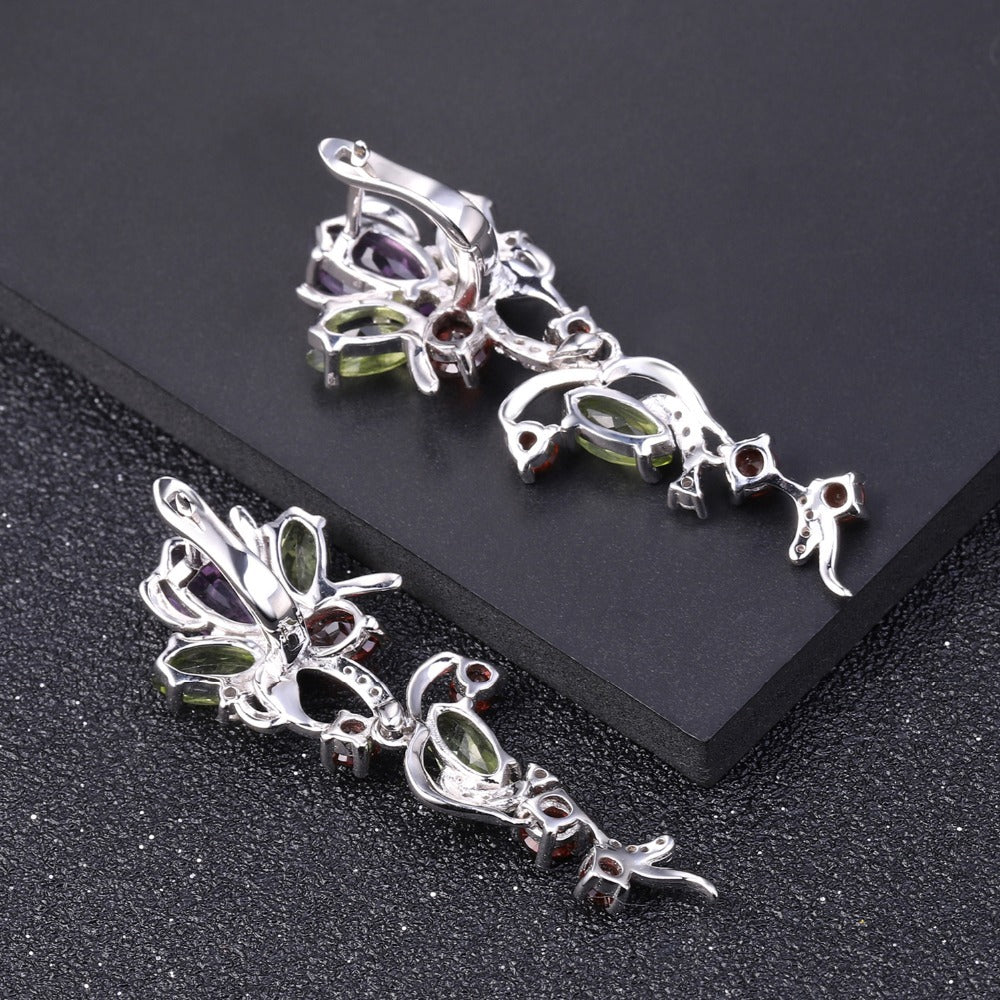 Pair of silver earrings with gemstones on a black background