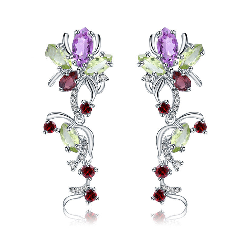 Pair of earrings with multicolored gemstones on a white background