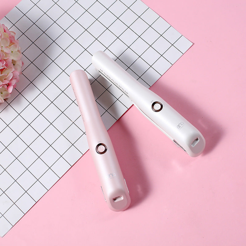 Two white electronic devices on a pink surface with a grid-patterned paper.