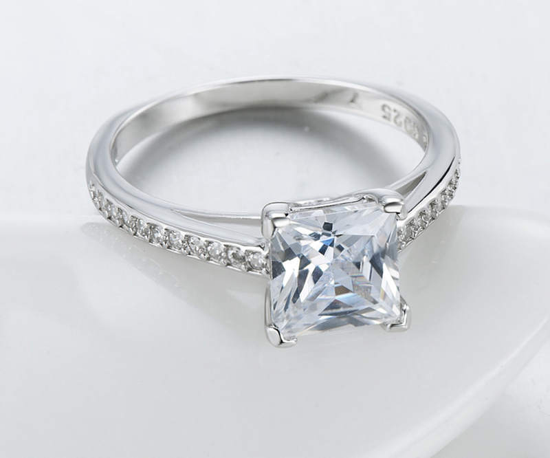 Silver ring with a large square-cut gemstone on a white background