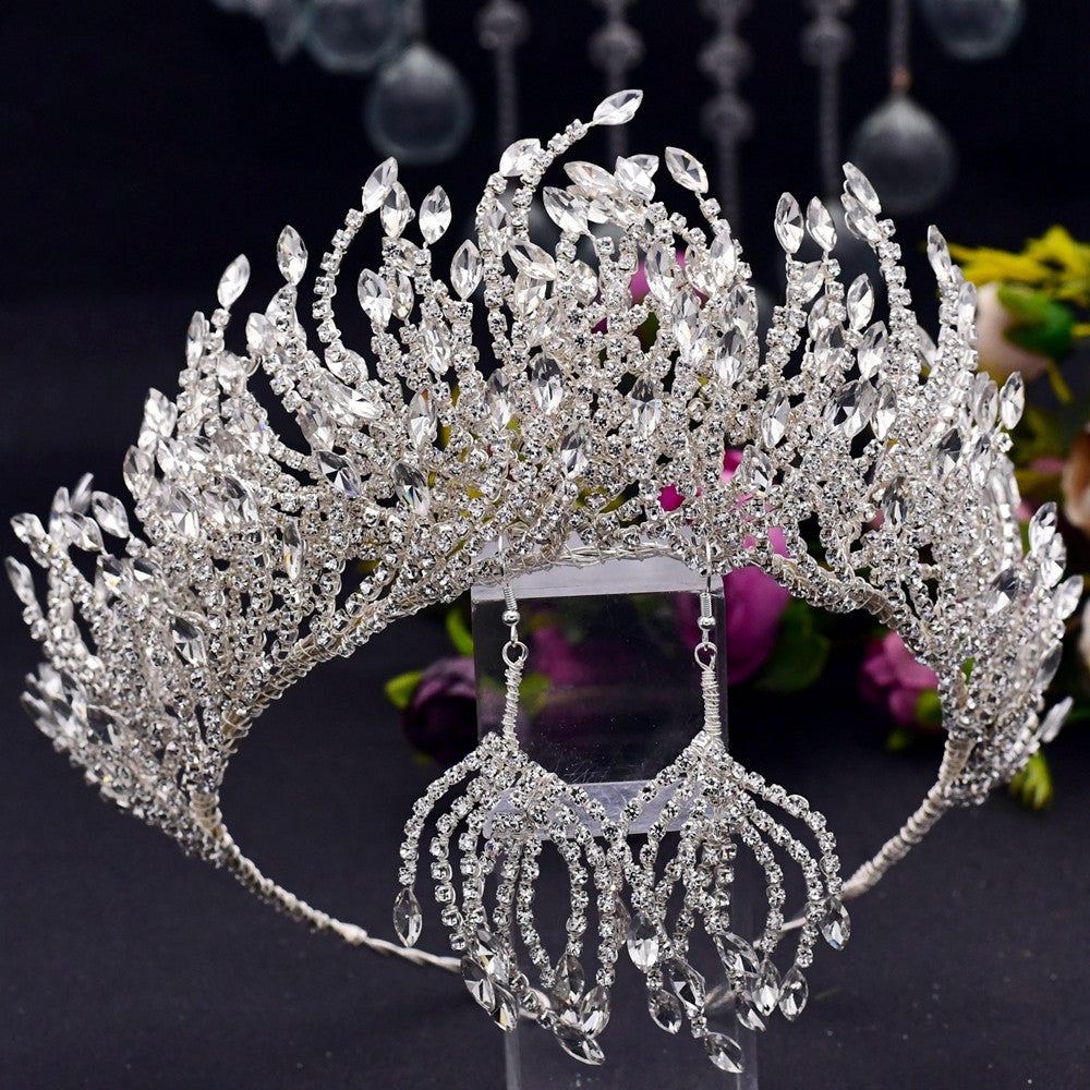 Elaborate silver tiara with crystal details on a dark background