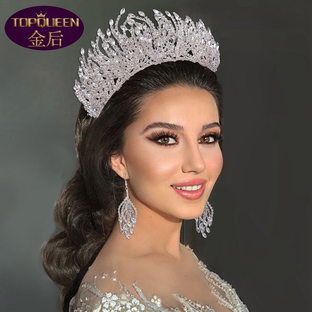 Woman wearing a sparkling tiara and earrings with a dark background