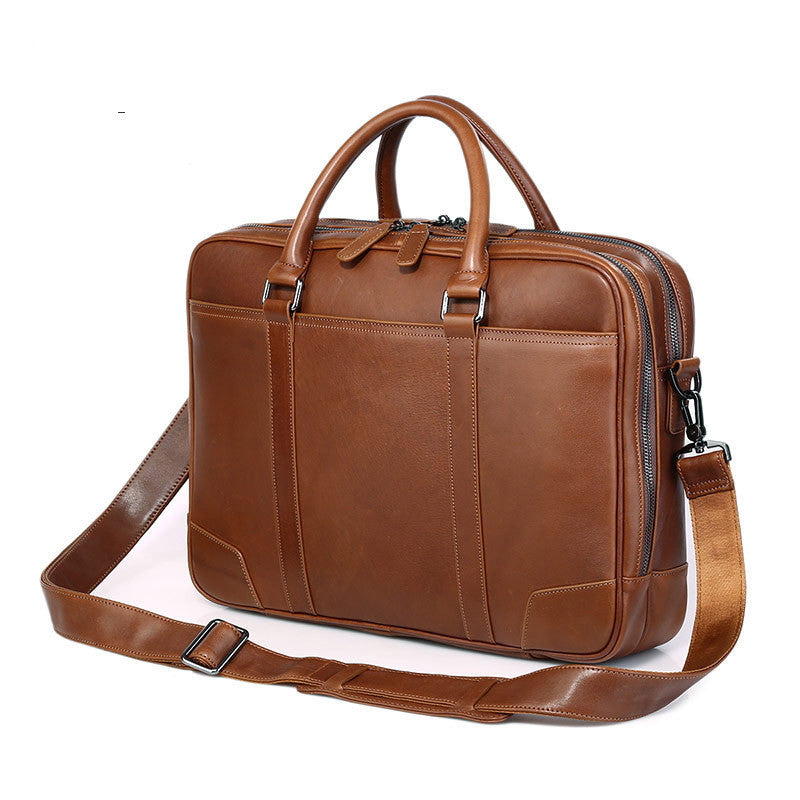 Brown leather briefcase with shoulder strap on a white background