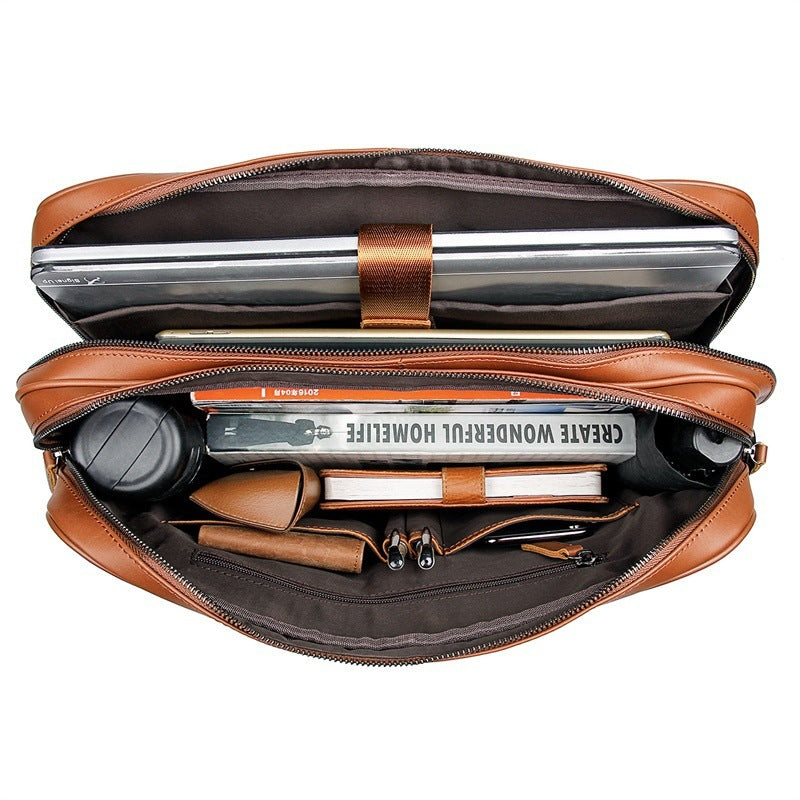 Open brown leather briefcase with laptop and office supplies on a white background