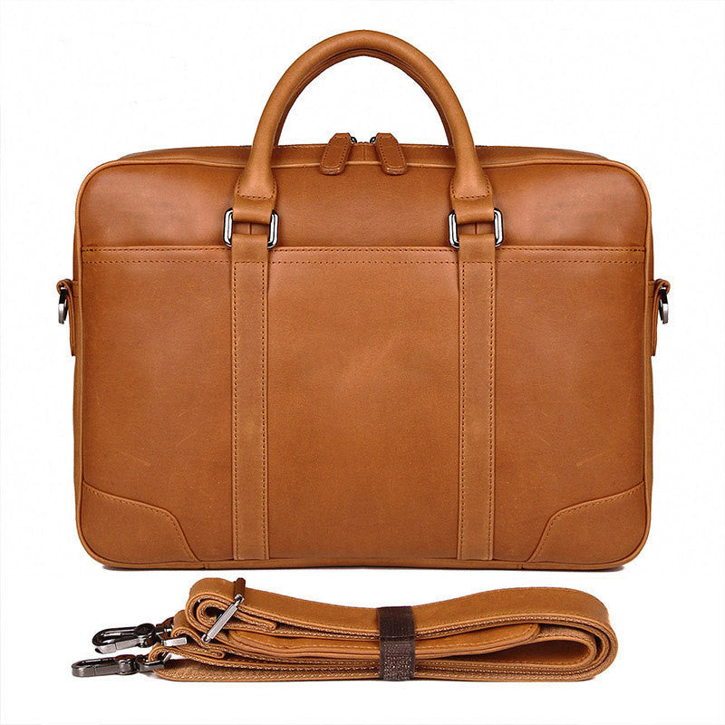 Brown leather briefcase with shoulder strap on a white background