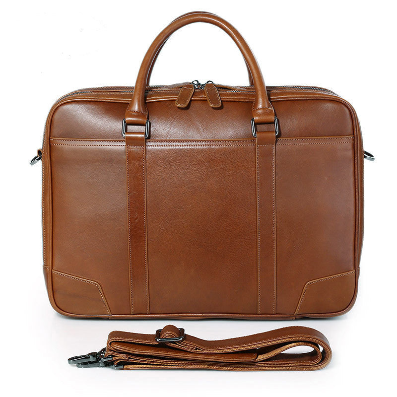 Brown leather briefcase with shoulder strap on a white background