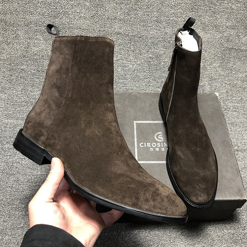 Brown suede ankle boots held by a hand with a Cirosi box in the background.