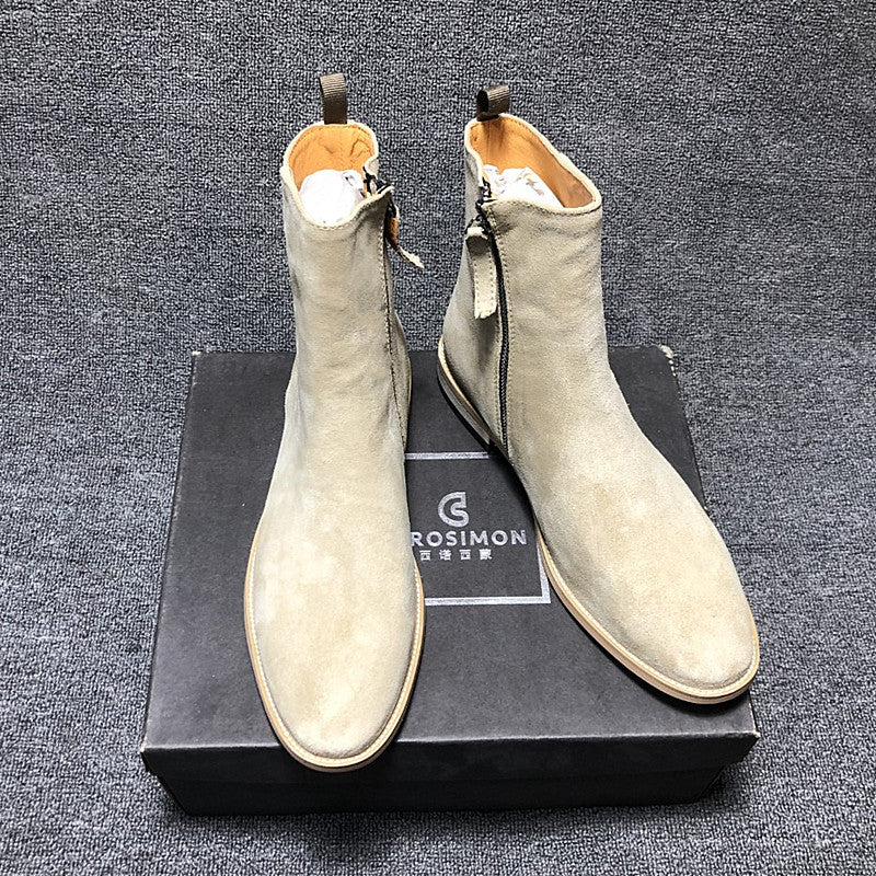 Pair of light gray suede boots on a black box with 'Grosvenor' branding against a dark textured background.