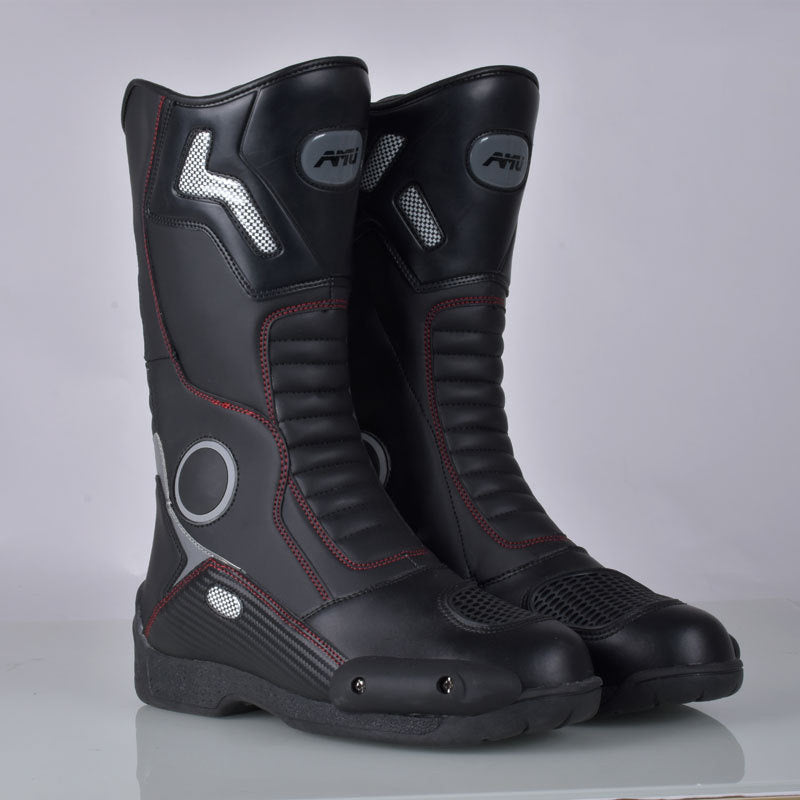 Pair of black motorcycle boots with red accents on a gray background