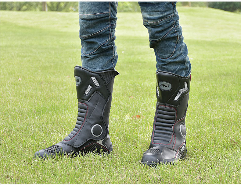 Black motorcycle boots worn on grass