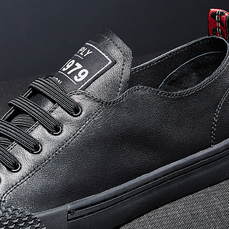 Black leather sneaker with a brand label on a dark background
