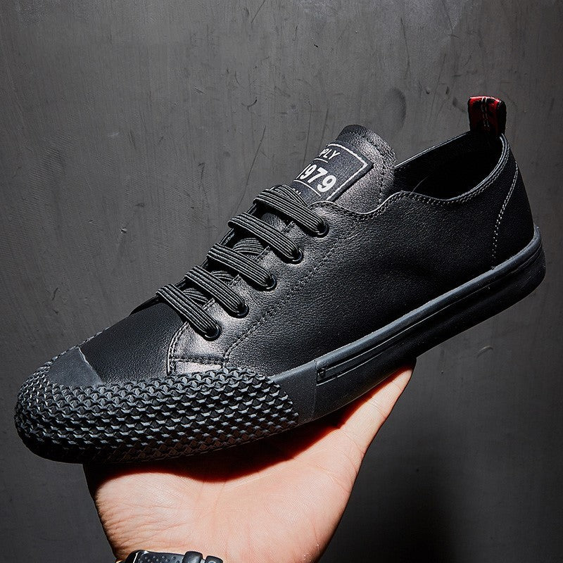 Black sneaker held in a hand against a dark background