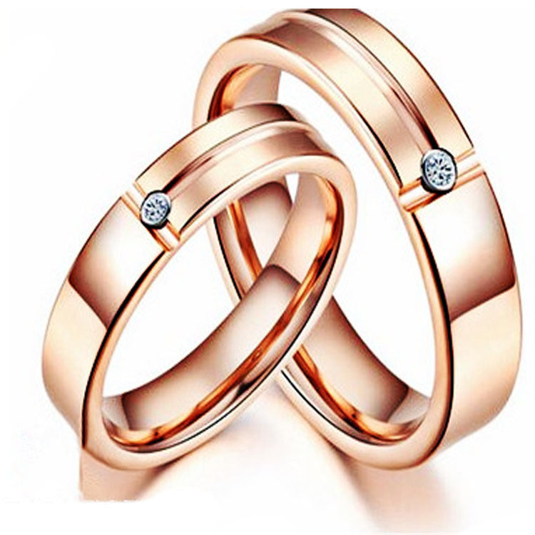 Rose gold ring with interlocking design and small diamonds on a white background