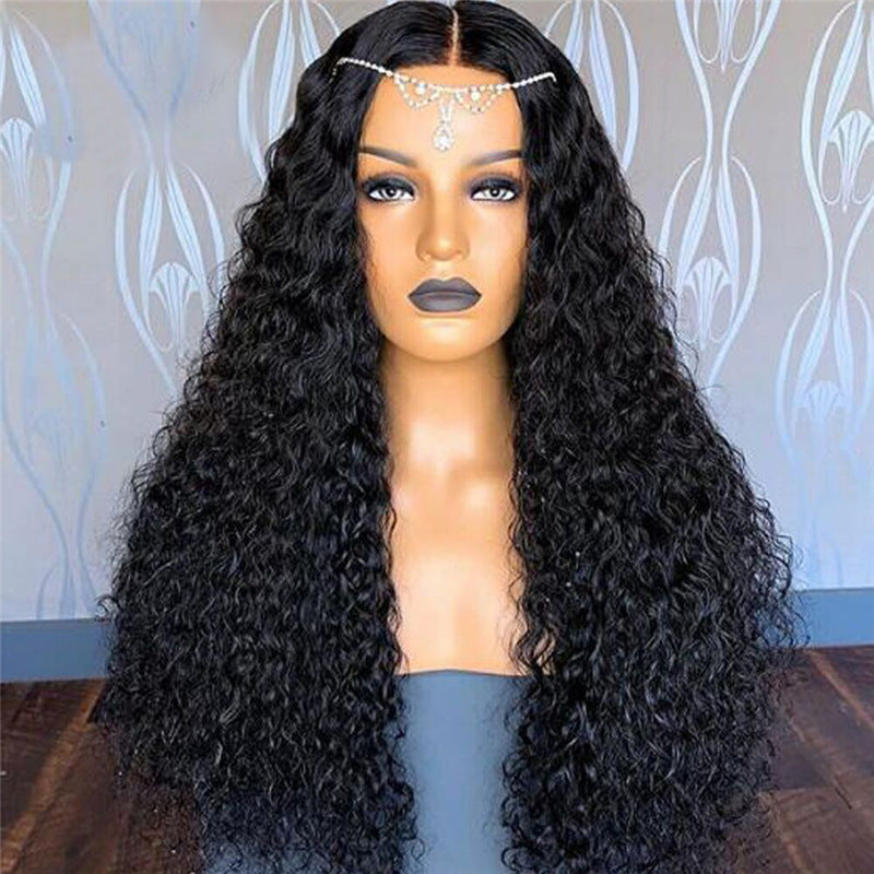 Mannequin head with long black curly wig against a decorative wall.