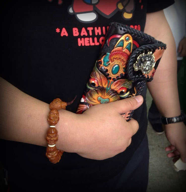 Person holding a colorful, intricately designed object with a black shirt in the background