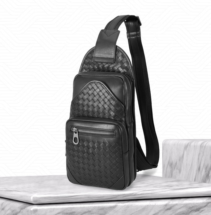 Black woven patterned sling bag on a marble surface