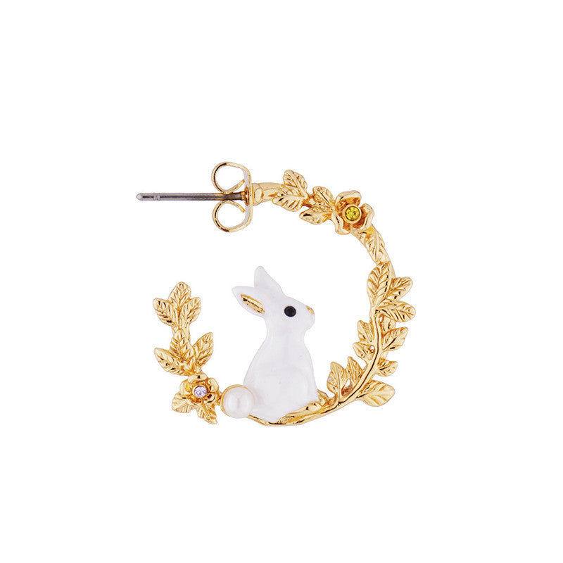 Gold hoop earrings with a white rabbit design on a white background
